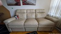 Front view of cream leather 3-seat reclining sofa
