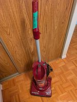 Full view of Dirt Devil Dynamite upright vacuum with handle and cord visible