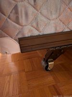 Corner of mattress, box spring fabric, metal frame leg with caster