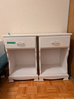 Front view of two matching white nightstands