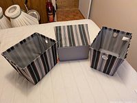 Three fabric storage bins displayed open