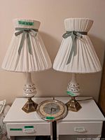 Front view of both lamps with shades and the wall clock placed between them