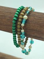 All three bracelets coiled together on wooden rod