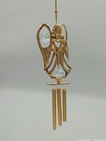 Full view of gold-plated angel wind chime with three tubes and crystals