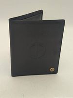Front view of black Dunhill wallet showing embossed logo and gold-tone emblem
