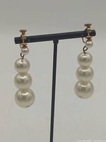 Front view showing both earrings with triple faux pearls and screw-back posts