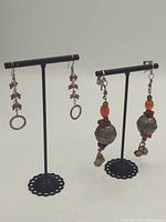 Both pairs of dangling earrings on stands