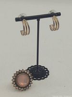 Earrings on stand and ring facing front