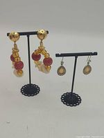 Both pairs of earrings on stands