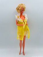 Full view of Barbie doll wearing yellow nightgown and robe
