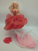 Full view of Barbie in red gown with accessories visible