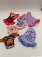 Six doll clothing pieces laid out for overview