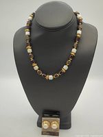 Full view beaded necklace on bust with earrings card below