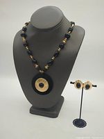 Full view of necklace on display bust with earrings on stand