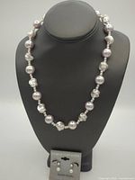 Necklace displayed on bust with earrings card below