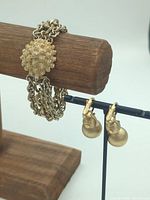 Bracelet displayed on stand with pair of earrings hanging below