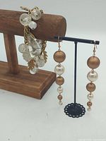 Bracelet draped on stand next to dangle earrings on display