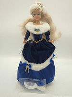 Full view of Barbie doll in blue gown with comb accessory