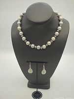 Full view of necklace on bust with earrings displayed below