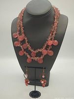 Full view of necklace displayed on bust with earrings on stand