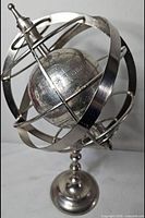 Overall view of silver-tone metal armillary globe on stand