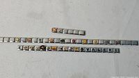 Three groups of Italian charm links, two full bracelets and one short strip
