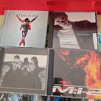 Four jewel-case CDs: Michael Jackson, Marc Anthony, U2, Mission: Impossible 2