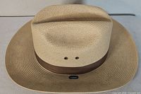 Top view of straw hat showing brim, crown ridge and ventilation eyelets