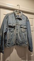 Front view of denim jacket on hanger