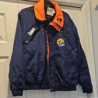 Front view of navy and orange racing jacket showing logos and number 17 patch