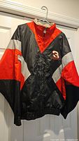 Full front view of color-block racing jacket on hanger