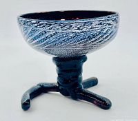 Side view of tripod art glass bowl