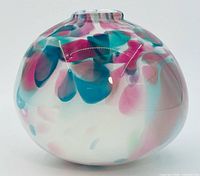Front view of spherical art glass vase showing teal and pink pattern