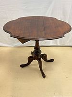 Oblique view of table fully open showing pedestal and legs