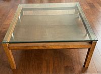 Top view of square wood frame coffee table with glass top