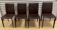 Four brown faux leather dining chairs front view
