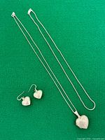 Necklace with heart locket, extra chain and matching earrings displayed