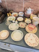 Overview of assorted bone-china plates, cups, shakers and accessories