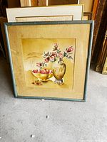 Full framed painting on floor showing teal frame, mat and artwork