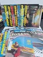 Front and back rows of Pool & Spa magazines, multiple cover designs visible