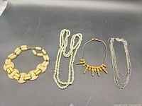 Group shot of four necklaces laid out side by side