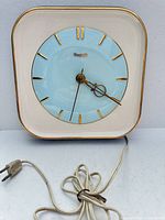Front view of square ceramic Forestville clock with cord visible