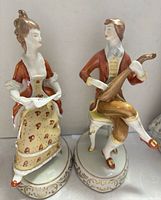 Front view of both Hollohaza porcelain figurines showing details and colors