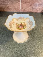Front view of pedestal bowl showing interior artwork and scalloped rim