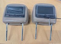 Front view of both Rosen AV7900 headrest DVD monitors showing screens and control buttons
