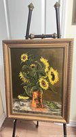 Full view of framed sunflower oil painting on easel