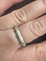 Ring worn on finger showing overall appearance and studded pattern