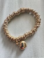 Full view of bracelet showing stacked rings and heart charm