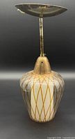 Full view of pendant showing brass canopy, stem, cap and patterned glass shade