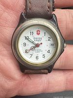 Front close-up of watch showing dial, logo, date window, bezel wear